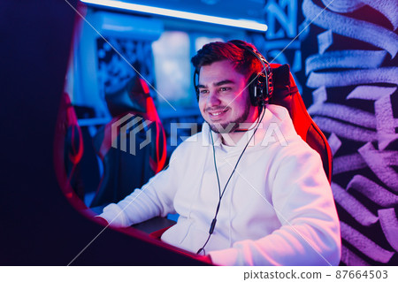 Guy playing gaming game on computer at game club. 87664503