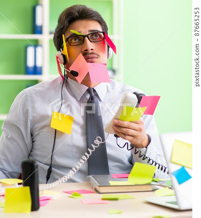 Young help desk operator working in office with many conflicting 87665253