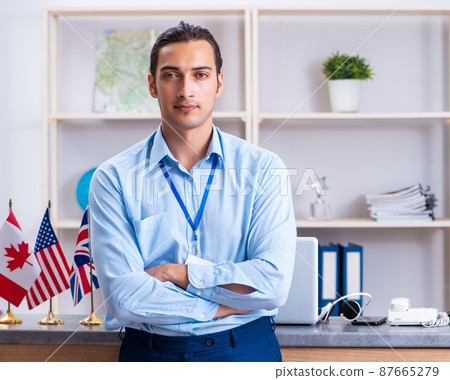 Young male travel agent working in the office 87665279