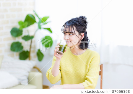 為健康喝綠汁的年輕女子 為健康喝綠汁的年輕女子 87666568