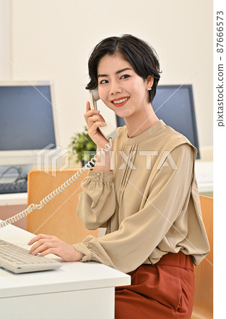 一個女人在辦公室打電話 一個女人在辦公室打電話 87666573