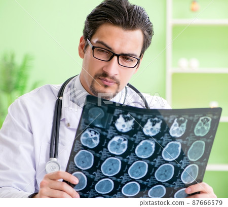 Doctor radiologist looking at x-ray scan in hospital Doctor radiologist looking at x-ray scan in hospital 87666579