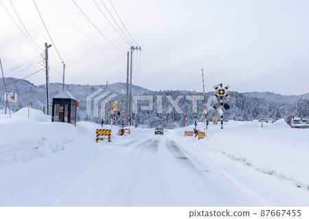 Railroad crossing in the countryside on a snowy day 87667455