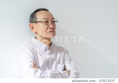 Senior male thinking arms folded Senior male thinking arms folded 87671037