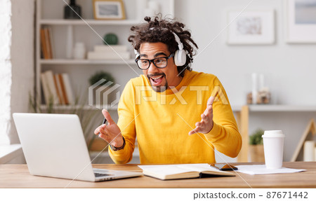 Young african american man working at laptop and talking via video call during self-isolation at home office Young african american man working at laptop and talking via video call during self-isolation at home office 87671442