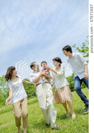 Three generation family playing in the park 87671687