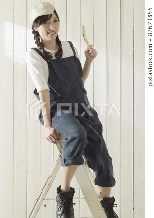 A woman applying paint 87671855