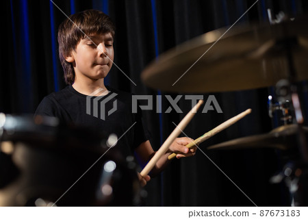 A boy plays drums in a recording studio A boy plays drums in a recording studio 87673183