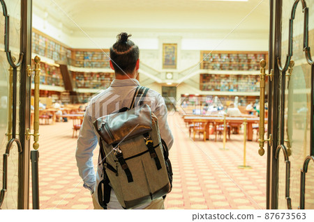 一名大學生參觀大型圖書館的背影 一名大學生參觀大型圖書館的背影 87673563