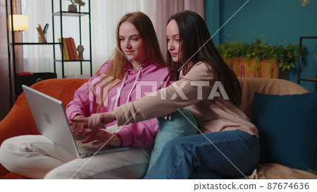 Girls friends siblings celebrate success win scream rejoices, doing online shopping on laptop pc 87674636