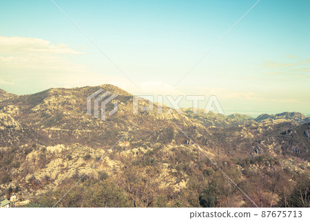 Aerial panoramic view of landscape with mountains and blue sky with white clouds. The horizontal landscape in mountains. Travel trip background for a post, screensaver, wallpaper, postcard, poster Aerial panoramic view of landscape with mountains and blue sky with white clouds. The horizontal landscape in mountains. Travel trip background for a post, screensaver, wallpaper, postcard, poster 87675713