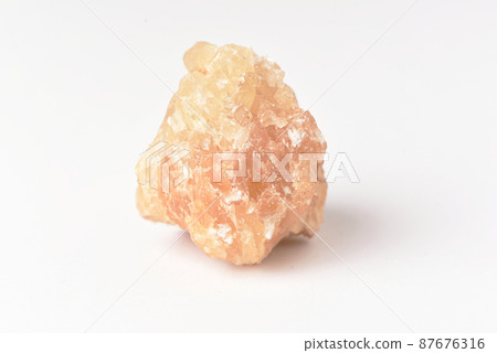One  uncut and rough Sunstone crystal,quartz on white 87676316
