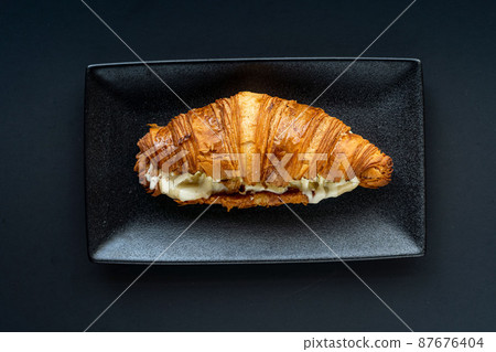 Croissant and a cup of tea on a neutral background selective focus 87676404