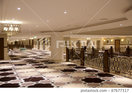 RAS AL KHAIMAH, UNITED ARAB EMIRATES - JUN 13, 2019: Spacious carpeted corridors in an opulent luxury hotel in the Arabian world like from Thousand and One Nights 87677317