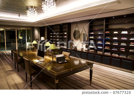 RAS AL KHAIMAH, UNITED ARAB EMIRATES - JUN 13, 2019: Workspace or well-stocked library with books, desks and computers in a 5-star luxury Arabian-style hotel RAS AL KHAIMAH, UNITED ARAB EMIRATES - JUN 13, 2019: Workspace or well-stocked library with books, desks and computers in a 5-star luxury Arabian-style hotel 87677328