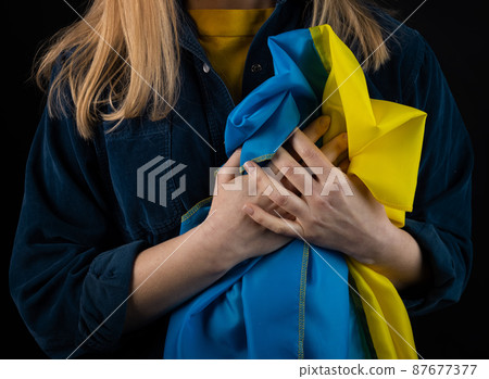 Woman holds ukrainian flag Woman holds ukrainian flag 87677377