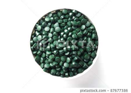 Green tablets made of natural organic spirulina in a cup on a white background with free space Green tablets made of natural organic spirulina in a cup on a white background with free space 87677386