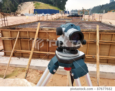 KUALA LUMPUR, MALAYSIA -AUGUST 16, 2021: Survey equipment used by the surveyor at the construction site. These tools are used to determine levels and coordinates for construction purposes. 87677682