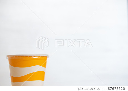 Yellow and white striped plastic cup for soft drinks with copy space Yellow and white striped plastic cup for soft drinks with copy space 87678320