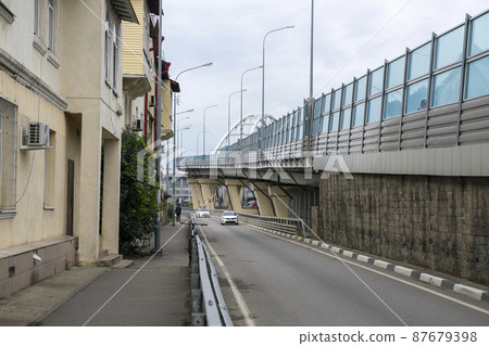 Overpass with glass panels against the blue sky. 87679398