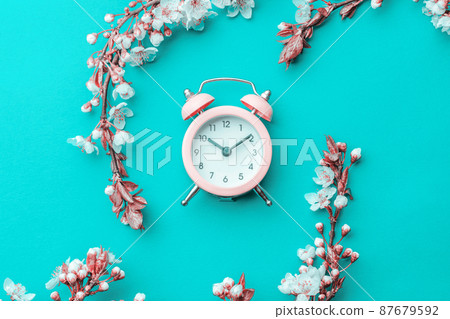 Cherry tree blossom. April floral nature and spring sakura blossom with alarm clock on soft blue background. Banner for 8 march, Happy Easter with place for text. Springtime concept. Cherry tree blossom. April floral nature and spring sakura blossom with alarm clock on soft blue background. Banner for 8 march, Happy Easter with place for text. Springtime concept. 87679592