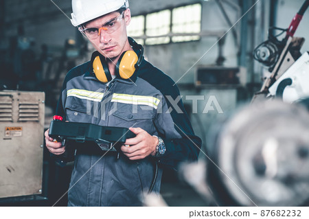 Young factory worker working with adept robotic arm Young factory worker working with adept robotic arm 87682232