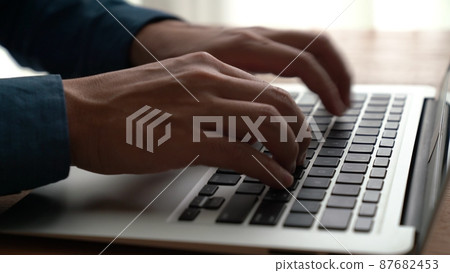Businessman hand works on capable laptop computer at office table close up shot Businessman hand works on capable laptop computer at office table close up shot 87682453