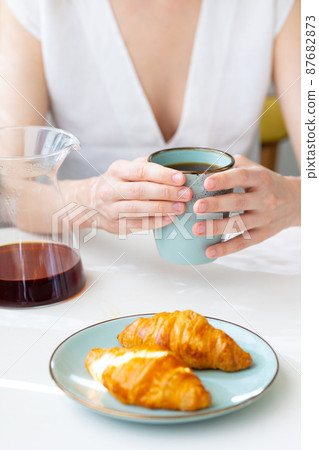 European woman brews coffee at home in her kitchen and enjoys her morning, good morning, caucasian woman makes coffee filter at home and enjoys her day off 87682873