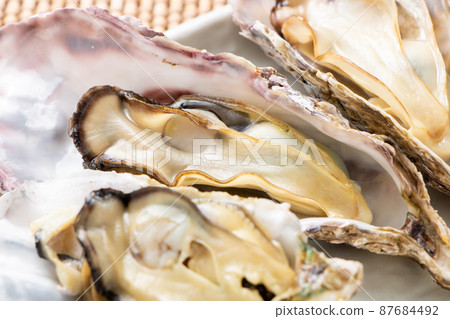 所謂的“微波牡蠣”是在微波爐中將其外殼附著在烤箱上加熱的。牡蠣的容易的烹調圖像與殼的。 87684492