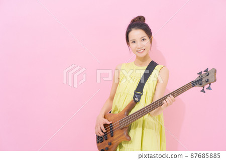 Female guitarist pink background Female guitarist pink background 87685885