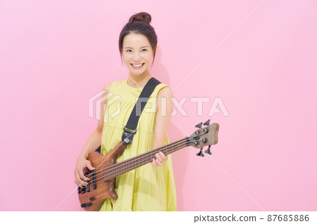 Female guitarist pink background Female guitarist pink background 87685886
