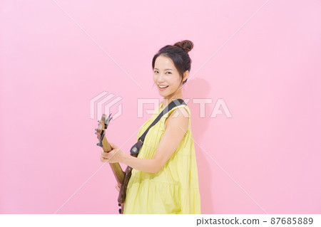女吉他手粉紅色背景 女吉他手粉紅色背景 87685889