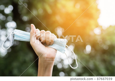 close up hand holding submit wearing facial hygienic mask nose outdoor. protection flu medical face mask against coronavirus. pandemic virus disease. Healthcare Covid 19 outbreak contamination concept close up hand holding submit wearing facial hygienic mask nose outdoor. protection flu medical face mask against coronavirus. pandemic virus disease. Healthcare Covid 19 outbreak contamination concept 87687039