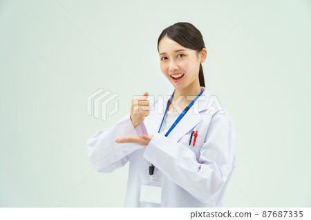 Woman in white coat giving back 87687335