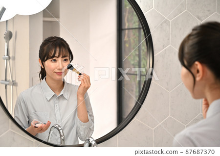 一個女人在鏡子前化妝 87687370