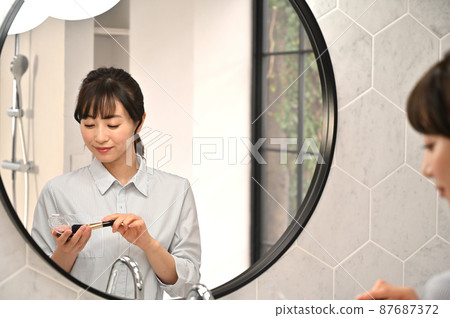 一個女人在鏡子前化妝 87687372