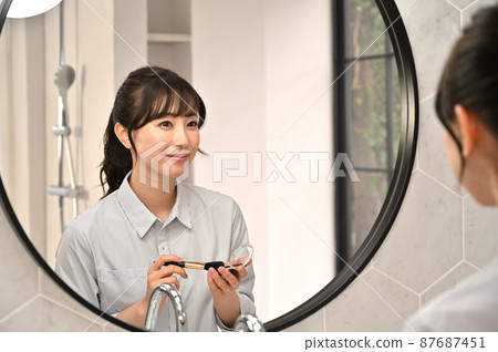 一個女人在鏡子前化妝 87687451