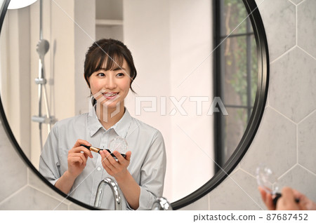 一個女人在鏡子前化妝 87687452