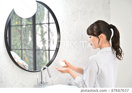 一個女人在鏡子前化妝 87687637