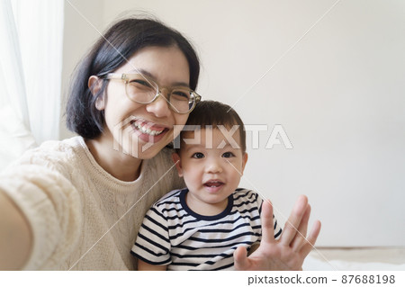 Young mother and her little cute boy making video call on using smartphone 87688198