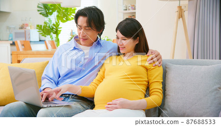asian pregnant couple use computer 87688533
