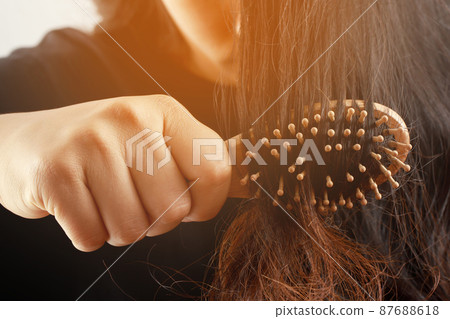 Rear view young woman worried about Hair loss problem, hormonal disbalance, stress concept. Many hair fall after combing in hair brush in hand. Female untangled her hair with a comb, Health care 87688618