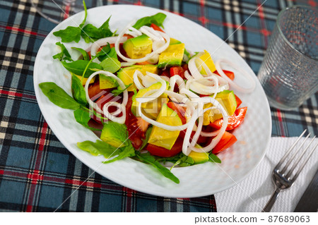 Salad with fresh tomatoes, avocado, onion and herbs Salad with fresh tomatoes, avocado, onion and herbs 87689063