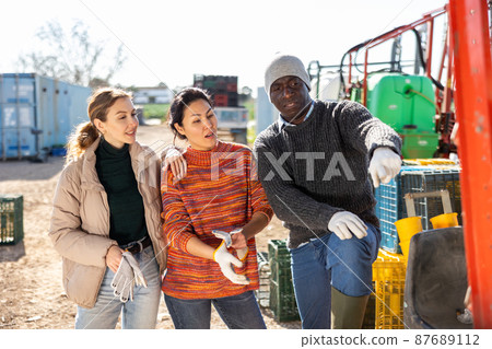 Multiethnic agriculturists having conversation during break outdoors Multiethnic agriculturists having conversation during break outdoors 87689112