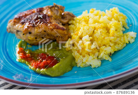 Baked chicken thighs and spicy rice with sauces Baked chicken thighs and spicy rice with sauces 87689136