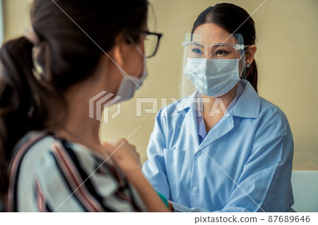 Young woman visits skillful doctor at hospital for vaccination Young woman visits skillful doctor at hospital for vaccination 87689646