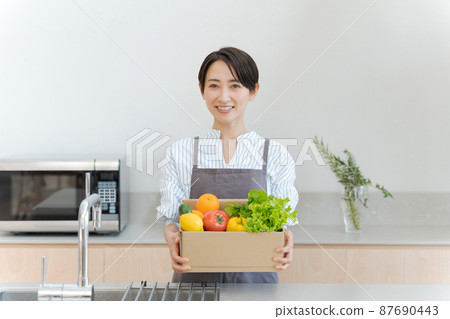 Woman holding vegetables 87690443