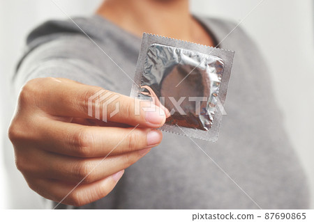 Condom ready to use in female hand, give safe sex concept on the bed Prevent infection and Contraceptives control the birth rate or safe prophylactic. World AIDS Day, 87690865