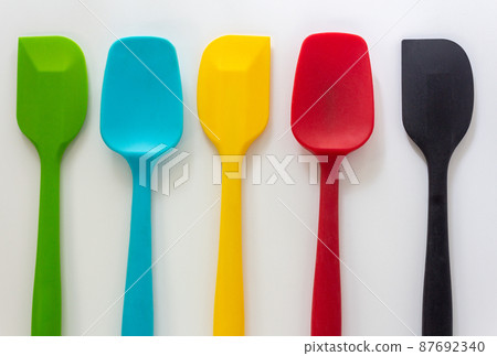 Silicone spatulas in various color, red, blue, green and yellow lay on white background 87692340