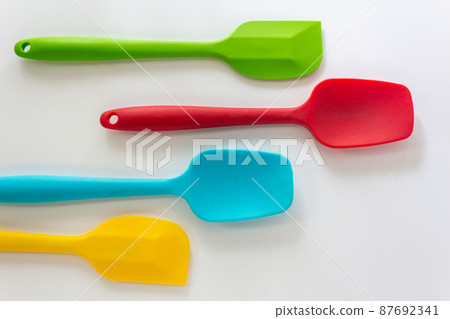 Silicone spatulas in various color, red, blue, green and yellow lay on white background 87692341
